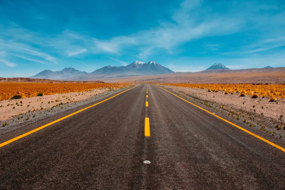 An empty road leading towards the mountains